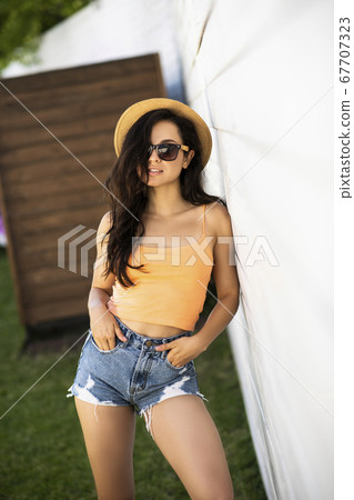 Pretty brunette girl in jeans shorts looking appealing Pretty brunette girl in jeans shorts looking appealing 67707323