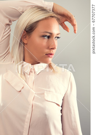 Pensive beautiful female blonde model in shirt looking away from camera Pensive beautiful female blonde model in shirt looking away from camera 67707377