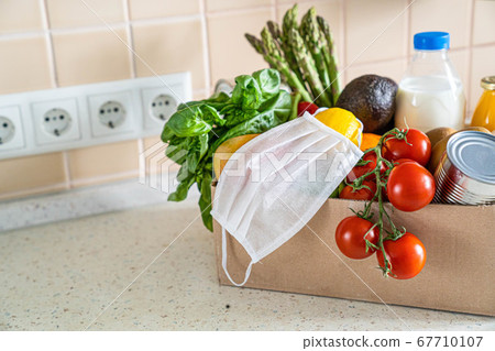 Safe food delivery concept - groceries in box with medical mask 67710107