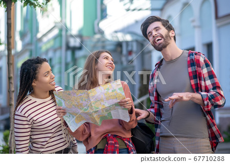 Bearded guy and two girls laughing fun outdoors 67710288