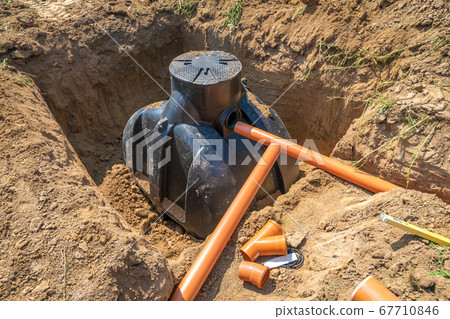 Plastic pipes in the ground for draining rainwater into the container 67710846