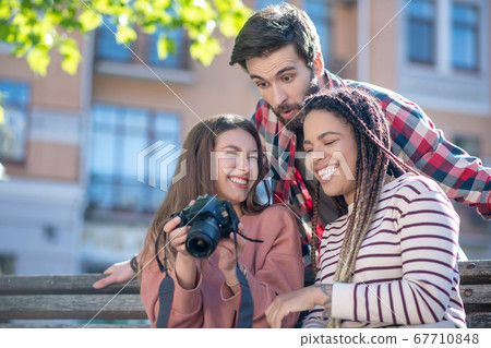 Having fun grimacing guy and two girls with camera 67710848