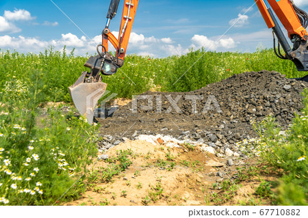the excavator digs gravel for road construction the excavator digs gravel for road construction 67710882