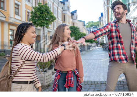 Inspired and funny guy and two girls outdoors 67710924