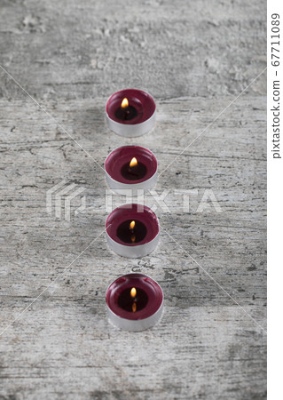 Small red flaming candles on the concrete ground, top view 67711089