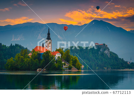 Hot air balloons over the lake Bled at sunrise, Slovenia Hot air balloons over the lake Bled at sunrise, Slovenia 67712113
