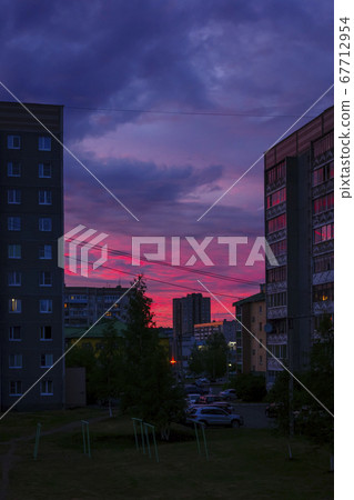 Dramatic cloudy sky with a crimson sunset in city, vertical form 67712954