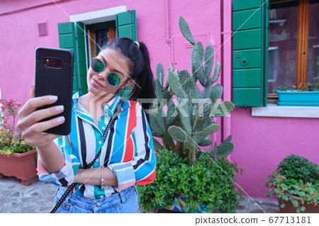 Happy young girl making pictures of herself 67713181