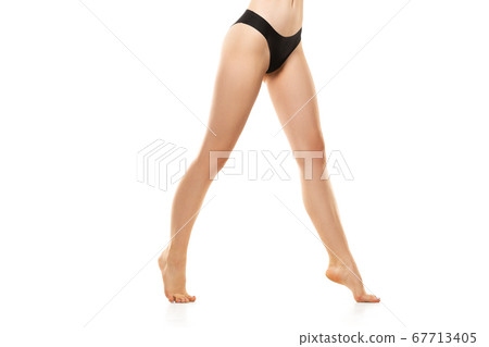 Beautiful female legs, buttlocks and belly isolated on white background. Sportive, sensual body with well-kept skin in underwear. 67713405