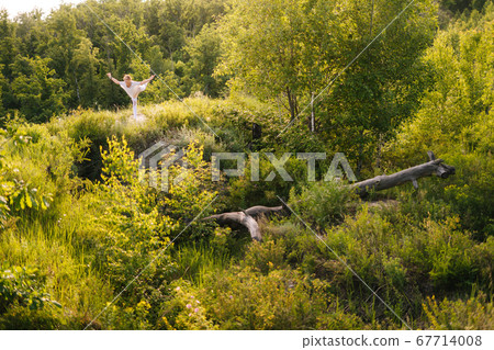 Sporty young woman practicing yoga, standing in Warrior three exercise, Virabhadrasana III pose 67714008