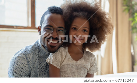 Portrait of happy biracial dad and daughter posing at home 67715247
