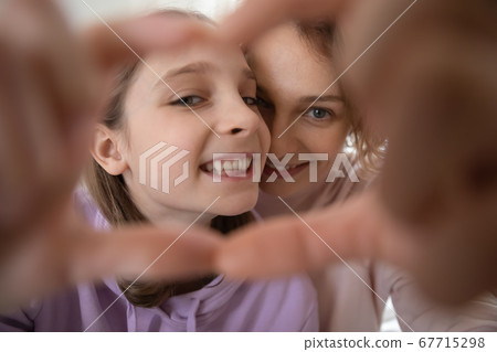 Close up happy mother and teenage daughter making heart gesture Close up happy mother and teenage daughter making heart gesture 67715298