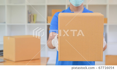 The delivery staff held a brown paper box. He was 67716054