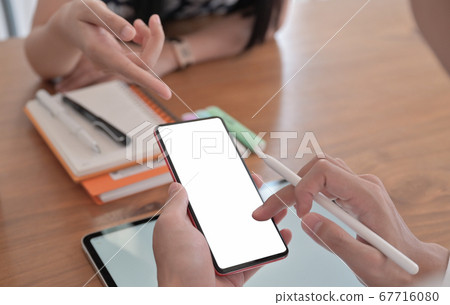 Cropped shot of a young woman pointing a Cropped shot of a young woman pointing a 67716080