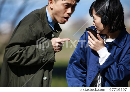 A woman who is warned by a man walking with a smartphone A woman who is warned by a man walking with a smartphone 67716597