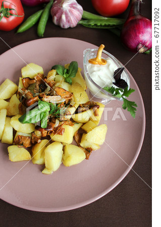 Fried potatoes with mushrooms with sauce and herbs close up 67717092