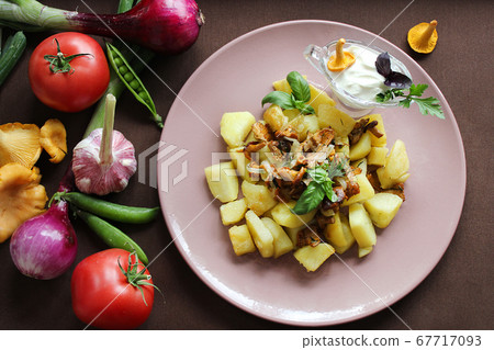 Hot dishes fried potatoes with chanterelles and vegetables close up Hot dishes fried potatoes with chanterelles and vegetables close up 67717093