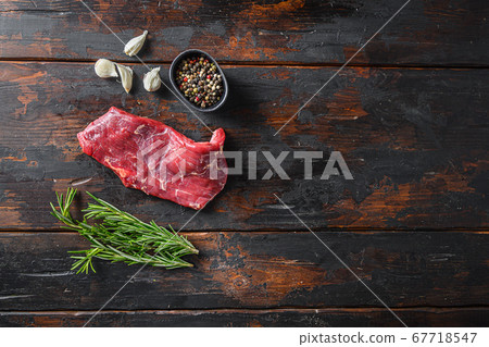 Flank, Bavette steak with seasonings, and fresh herbs raw meat, marbled beef . Dark wood rustic background. Top view space for text Flank, Bavette steak with seasonings, and fresh herbs raw meat, marbled beef . Dark wood rustic background. Top view space for text 67718547