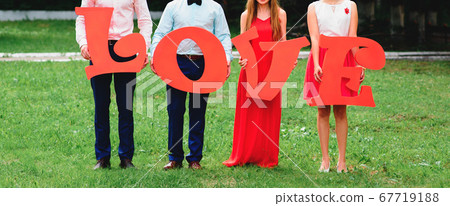 friends holding large wooden letters love outdoors friends holding large wooden letters love outdoors 67719188