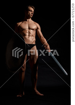Young warrior with shield isolated on black. Young warrior with shield isolated on black. 67721259