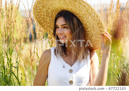 Young happy woman in big straw hat  67722183