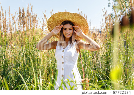 Young happy woman in big straw hat Young happy woman in big straw hat 67722184