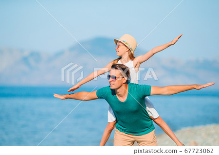 Little girl and happy dad having fun during beach vacation 67723062