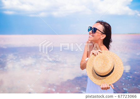 Young beautiful woman having fun on tropical seashore. Happy girl background the blue sky and turquoise water in the sea Young beautiful woman having fun on tropical seashore. Happy girl background the blue sky and turquoise water in the sea 67723066