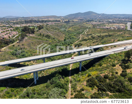 Aerial view of road highway bridge, viaduct supports in the valley among the green hills. 67723613