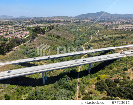Aerial view of road highway bridge, viaduct supports in the valley among the green hills. 67723615