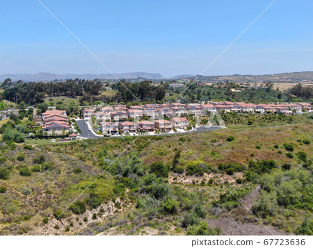 Aerial view of upper middle class neighborhood with residential houses in green valley  67723636