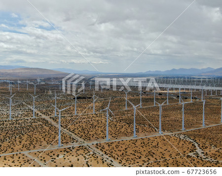 Aerial view of huge array of gigantic wind turbines spreading over the desert in Palm Springs. Aerial view of huge array of gigantic wind turbines spreading over the desert in Palm Springs. 67723656