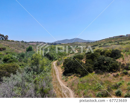 Aerial view of a small singletrack trail in green valley Aerial view of a small singletrack trail in green valley 67723689