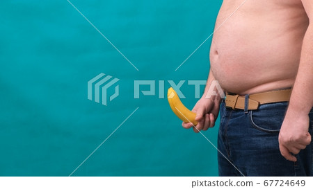 old limp drooping banana hanging from genital area of clothed unrecognizable man, impotence erectile 67724649
