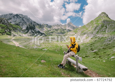 man travel with dog using smartphone at countryside with mountains scenic view 67724792