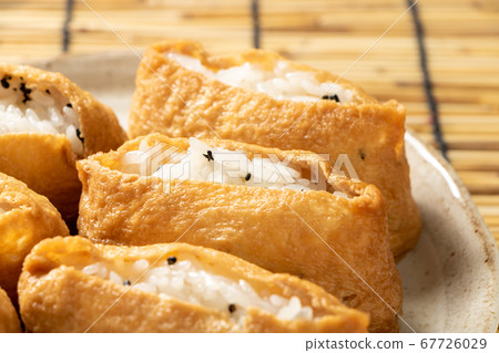 Inari sushi with black sesame. Background, blinds. 67726029