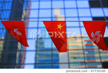 chinese and hong kong flags blow in the wind with glass building background 67730180