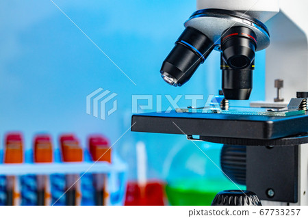 Close up photo of microscope with test tubes with blood samples Close up photo of microscope with test tubes with blood samples 67733257