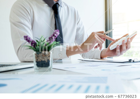 business man is sitting at a desk and use calculator calculating financial graph that show results In the office business man is sitting at a desk and use calculator calculating financial graph that show results In the office 67736023