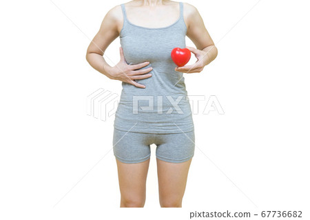 woman in gray clothes holding red heart put on the chest area,Health-care concept on white background, healthy girl medical awareness cancer prevention concept 67736682