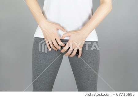 Cropped of woman in gray shorts put her hand on the genitalia area, Penis pain or Itching urinary Health-care concept on gray background with copy space 67736693