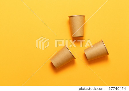 Paper cups on an orange background Paper cups on an orange background 67740454
