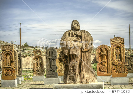 Monument to the founder of the Armenian alphabet Saint Mesrop Mashtots on the background of letters carved from stone 67741083