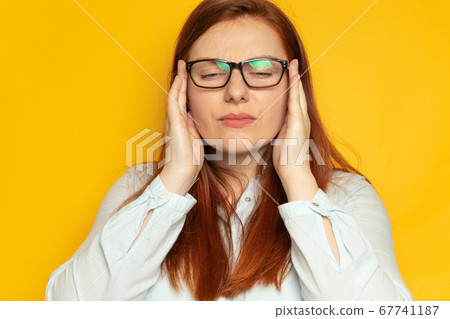 Depression unhappy woman with bipolar disorder clings to her head and experiences a headache. 67741187