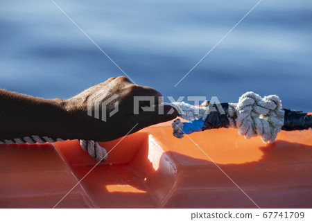 hand of black Migrant detail on boat 67741709