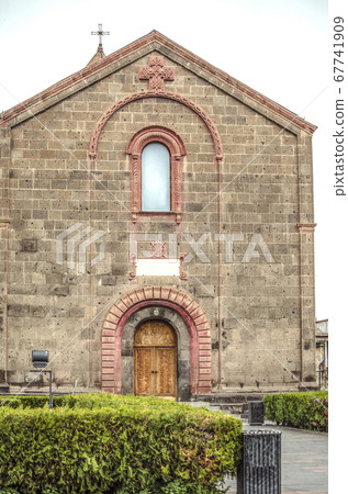 Decorative patterned arches and openwork cross under the roof on the facade of the Church of St. Mesrop Mashtots in the village of Oshakan Decorative patterned arches and openwork cross under the roof on the facade of the Church of St. Mesrop Mashtots in the village of Oshakan 67741909