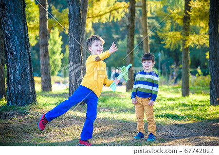 Happy two brother kids playing with toy airplane Happy two brother kids playing with toy airplane 67742022