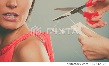 Woman cutting off removing label board price tag. 67742125