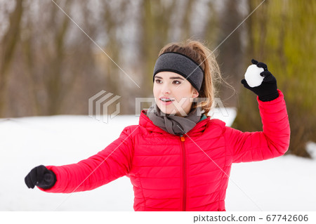 Sporty woman throwing snowball 67742606