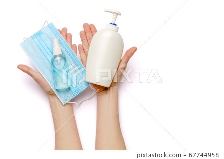 Female hands holding liquid soap or hand sanitizer spray dispenser and medical protective mask isolated on white background with clipping path Female hands holding liquid soap or hand sanitizer spray dispenser and medical protective mask isolated on white background with clipping path 67744958